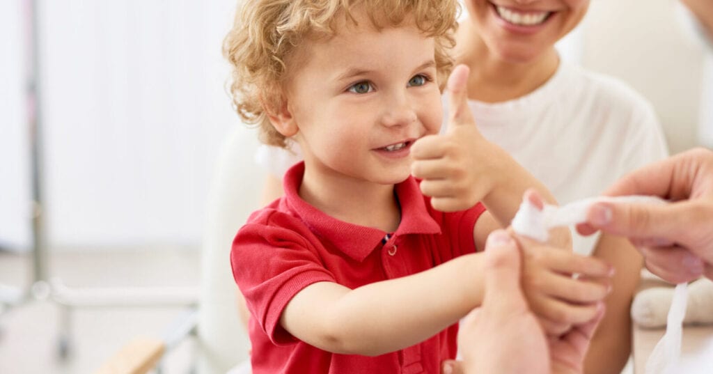 A happy young boy with a bandaged thumb