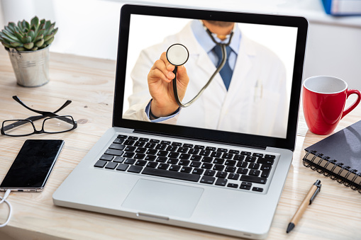 A doctor with a stethoscope in a laptop