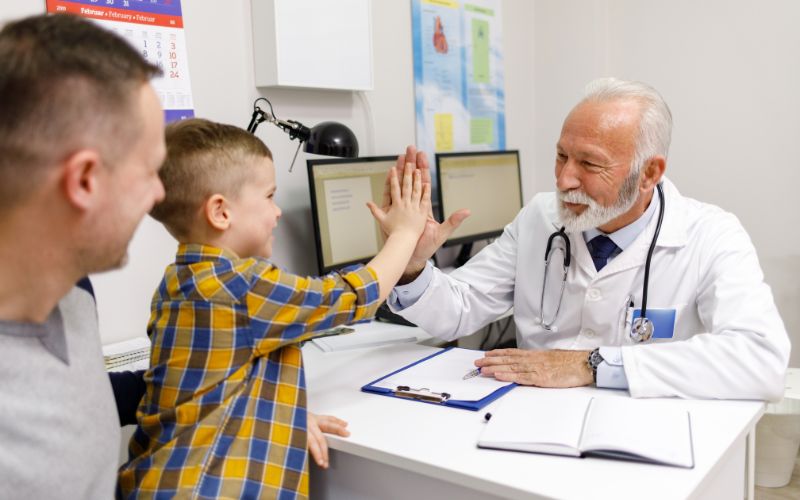 Little boy and pediatrician doing high five