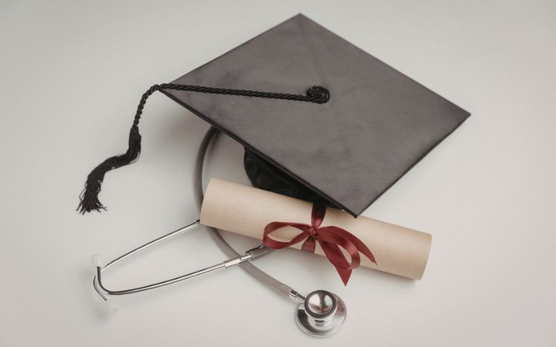 graduation cap diploma and stethoscope symbolizing medical education achievement