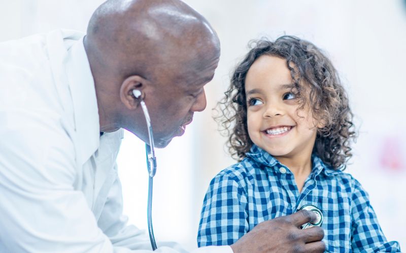 male pediatrician checking a little kid