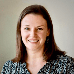 Smiling woman with brown hair and blouse.