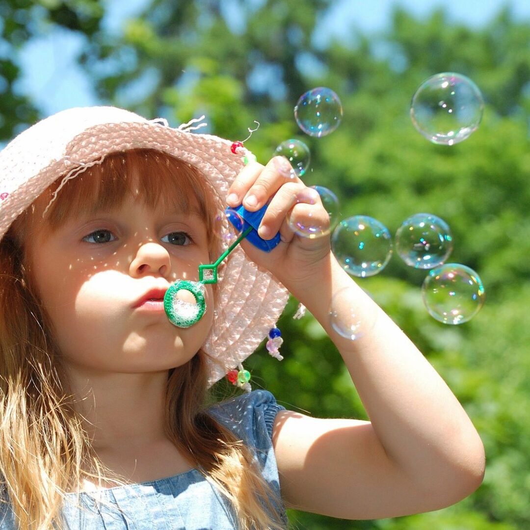 A young girl blowing bubbles